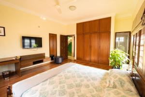 a bedroom with a bed and a flat screen tv at Luho 187 in Bangalore