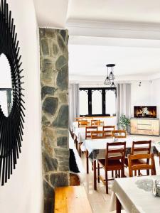 a dining room with tables and chairs and a stone wall at Willa Tulula in Kościelisko