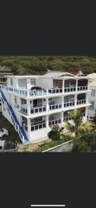 a large white building with a palm tree in front of it at Morne Side Apartments in La Gaulette