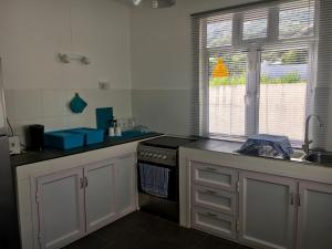 a kitchen with a stove and a sink and a window at Morne Side Apartments in La Gaulette