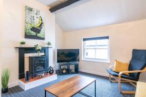 a living room with a fireplace and a tv at Characterful 2 bedroom apartment - Central location in Castle Donington