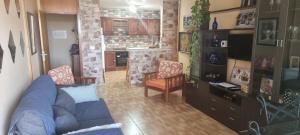 salon z niebieską kanapą i kuchnią w obiekcie casa Carolina y Roger tazacorte w mieście Tazacorte