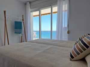 sypialnia z łóżkiem i widokiem na ocean w obiekcie EDIFICIO RIO w mieście Calpe
