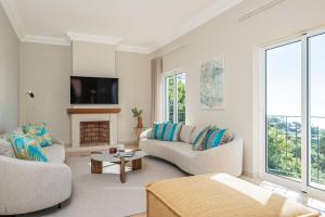 uma sala de estar com dois sofás e uma lareira em Villa Sea Renity - Palheiro Village by ALMA Holiday Rentals em Funchal