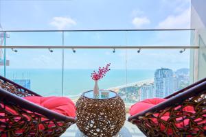 a balcony with two chairs and a vase on a table at T-Plantino - Căn hộ Codotel The Sóng 5 Sao - Free swimmingpool, Gym, Sauna in Vung Tau