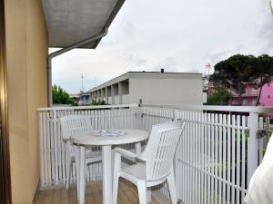 d'une table blanche et de deux chaises sur un balcon. dans l'établissement Luminous flat 400 m from the beach for 4 guests, à Bibione