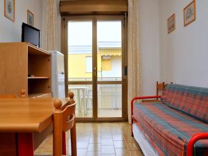 - un salon avec un lit, une table et une fenêtre dans l'établissement Luminous flat 400 m from the beach for 4 guests, à Bibione