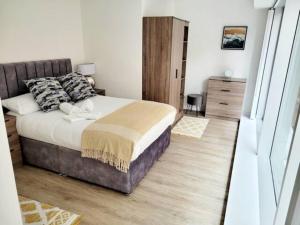 a bedroom with a large bed and a wooden floor at Brand New Luxury 1-Bed Apartment in Liverpool in Liverpool