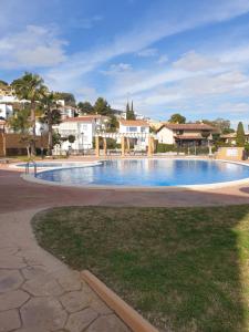 a swimming pool in a resort with buildings in the background at En la gloria. in Peniscola