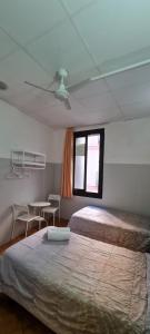 バルセロナにあるペンション 45のベッドルーム1室(ベッド2台、テーブル、窓付)