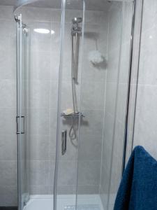 a shower with a glass door in a bathroom at Convenient 3BR close to QE Hospital & University of Birmingham in Birmingham