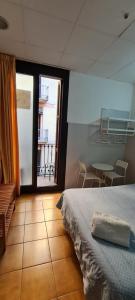1 dormitorio con cama, mesa y ventana en Pensión 45, en Barcelona