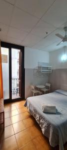 1 dormitorio con 1 cama y 1 mesa con sillas en Pensión 45, en Barcelona