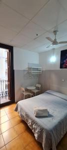 - une chambre avec un lit et une table avec des chaises dans l'établissement Pensión 45, à Barcelone