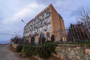 un bâtiment avec une clôture devant lui dans l'établissement Kirovakan Hotel, à Vanadzor