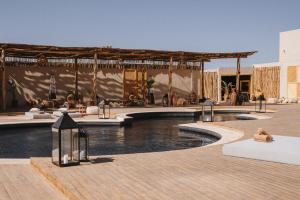 a resort with a swimming pool and a pavilion at Caravan by Habitas Dakhla in Dakhla