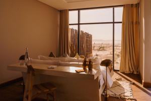 a living room with a couch and a large window at Caravan by Habitas Dakhla in Dakhla