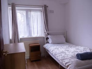 a small bedroom with a bed and a window at Convenient 3BR close to QE Hospital & University of Birmingham in Birmingham