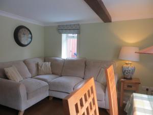 sala de estar con sofá y mesa en Easter Cottage, en Dersingham