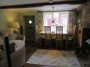 sala de estar con mesa de comedor y sillas en Easter Cottage, en Dersingham