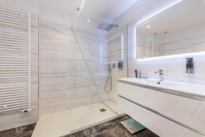 Un baño blanco con lavabo y ducha. en Center Salo, en Saló 17 fotos más