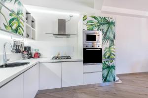 Una cocina blanca con gabinetes blancos y un microondas. en Center Salo, en Saló