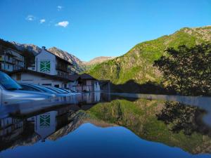 um reflexo de casas sobre a água com montanhas ao fundo em B&B CA' DEL PITUR CICOGNA em Cossogno