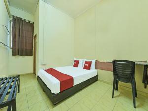 1 dormitorio con 1 cama y 1 silla en OYO 90706 Empire Inn 2 en Kota Bharu