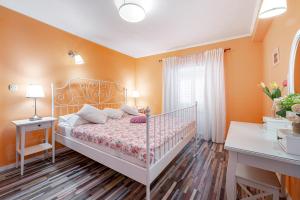 a bedroom with orange walls and a bed with a white crib at Apartments Vera in Dubrovnik