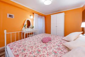 a bedroom with orange walls and a large bed at Apartments Vera in Dubrovnik