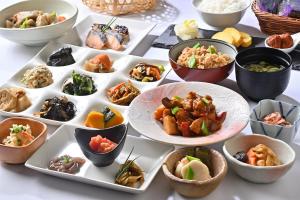 a table topped with bowls of different types of food at Hotel Keihan Sapporo in Sapporo