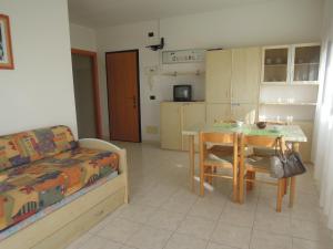 Habitación con cocina, mesa y cama en Homely 1 bedroom flat with side sea view, en Bibione