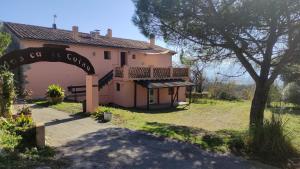 an entrance to a large pink house with a tree at La casa de l'Avi in Tortellá