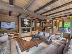 ein Wohnzimmer mit Sofa und Tisch in der Unterkunft Chalet familial avec jacuzzi et salle de cinéma - FR-1-565-65 in Les Allues
