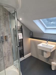 ein Bad mit einem Waschbecken und einer Dusche in der Unterkunft Brathay Lodge in Ambleside