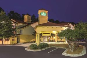 ein Hotel mit Uhrturm auf einem Parkplatz in der Unterkunft La Quinta Inn & Suites by Wyndham University Area Chapel Hill in Durham