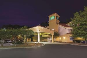 un gran edificio con una torre de reloj por la noche en La Quinta Inn & Suites by Wyndham University Area Chapel Hill, en Durham