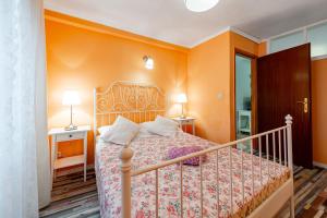a bedroom with a bed with an orange wall at Apartments Vera in Dubrovnik