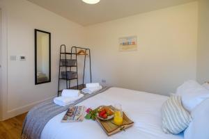 a bedroom with a tray of fruit on a bed at Three Tuns - Garden Suite 3 in Wickham Market