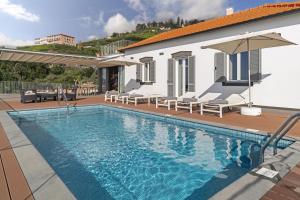 - une piscine avec des chaises et une maison dans l'établissement Stunning Funchal Villa - 3 Bedrooms - Vila da Portada - Panoramic Sea Views - Recently Refurbished, à Funchal