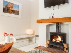 a living room with a fireplace and a tv at Crud Yr Awel in Canterbury