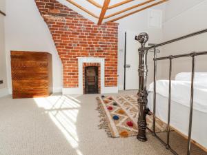 a bedroom with a bed and a brick wall at Crud Yr Awel in Canterbury