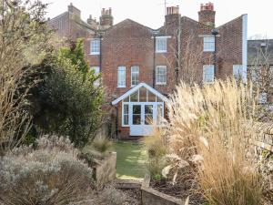 an old brick house with a garden in front of it at Crud Yr Awel in Canterbury