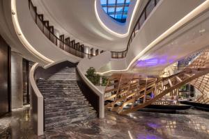 a spiral staircase in a building with a ceiling at Wyndham Grand Shanxi Xiaohe Xincheng in Taiyuan