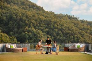 un gruppo di persone sedute a un tavolo su un tetto di Hyatt Regency Dehradun Resort and Spa a Dehradun