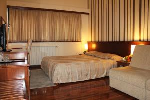 a hotel room with a bed and a couch at Hotel Centar in Skopje