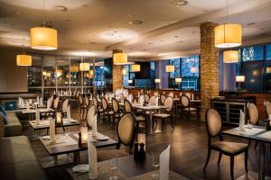 a restaurant with tables and chairs and lights at Rilano 24/7 Hotel München in Munich