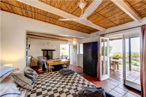 a bedroom with a bed and a ceiling fan at !Khwa ttu in Swartwater