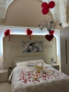 "Lu Barocco" a soli 10 min da Torre Lapillo في سان بانكرازيو سالنتينو: غرفة نوم عليها سرير بقلوب حمراء