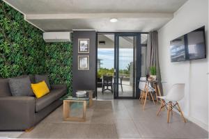 uma sala de estar com um sofá e uma mesa em Modern Ground Floor Studio Apartment em Umhlanga